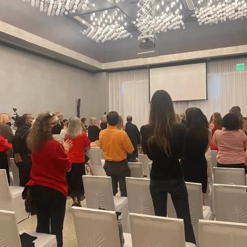 Attendees standing together at the front of a conference room