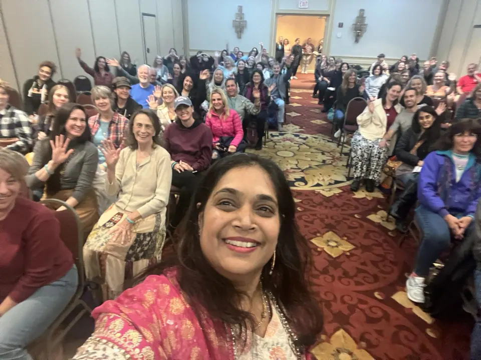 Bhavna smiling in front of a large audience at a gathering