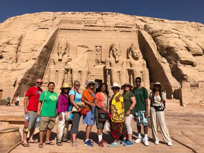 A tour group posed in front of the colossal statues at Abu Simbel, Egypt