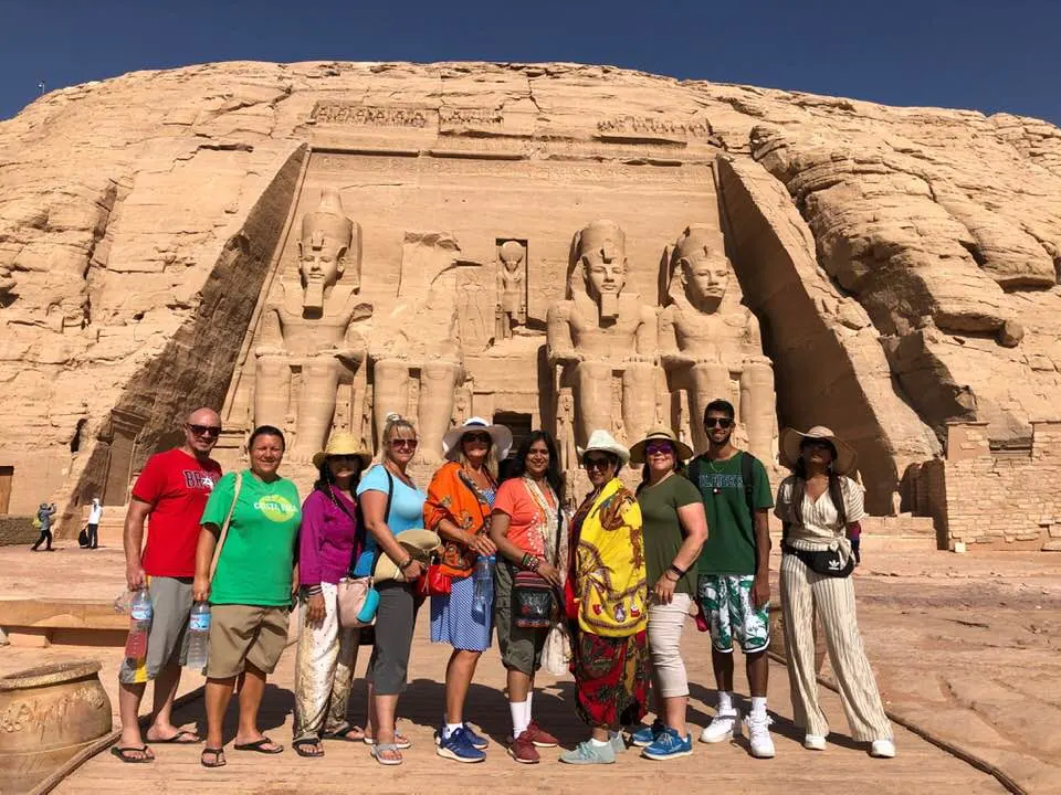 A tour group posed in front of the colossal statues at Abu Simbel, Egypt