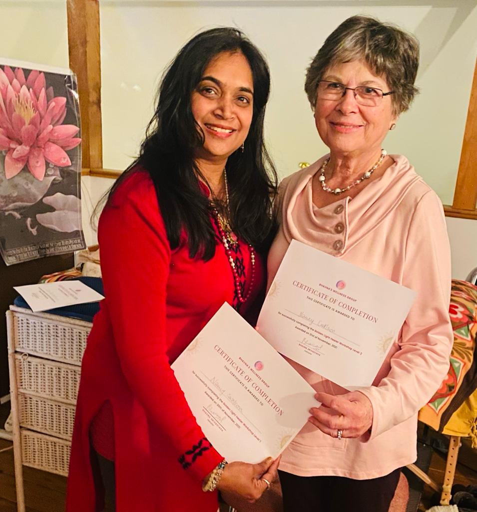 Bhavna Srivastava presenting a certificate of completion to an older graduate dressed in pink