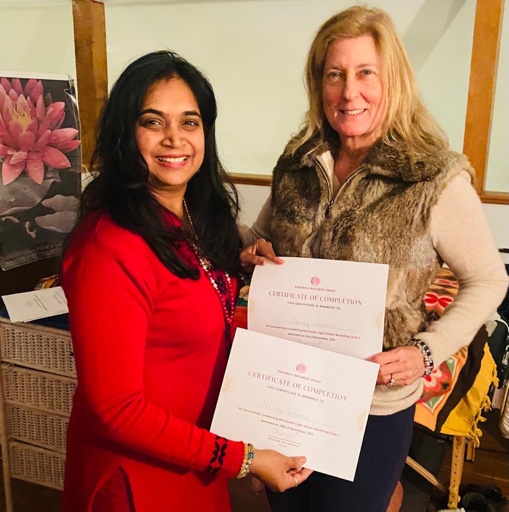 Bhavna Srivastava presenting a certificate of completion to a graduate in an animal-print jacket