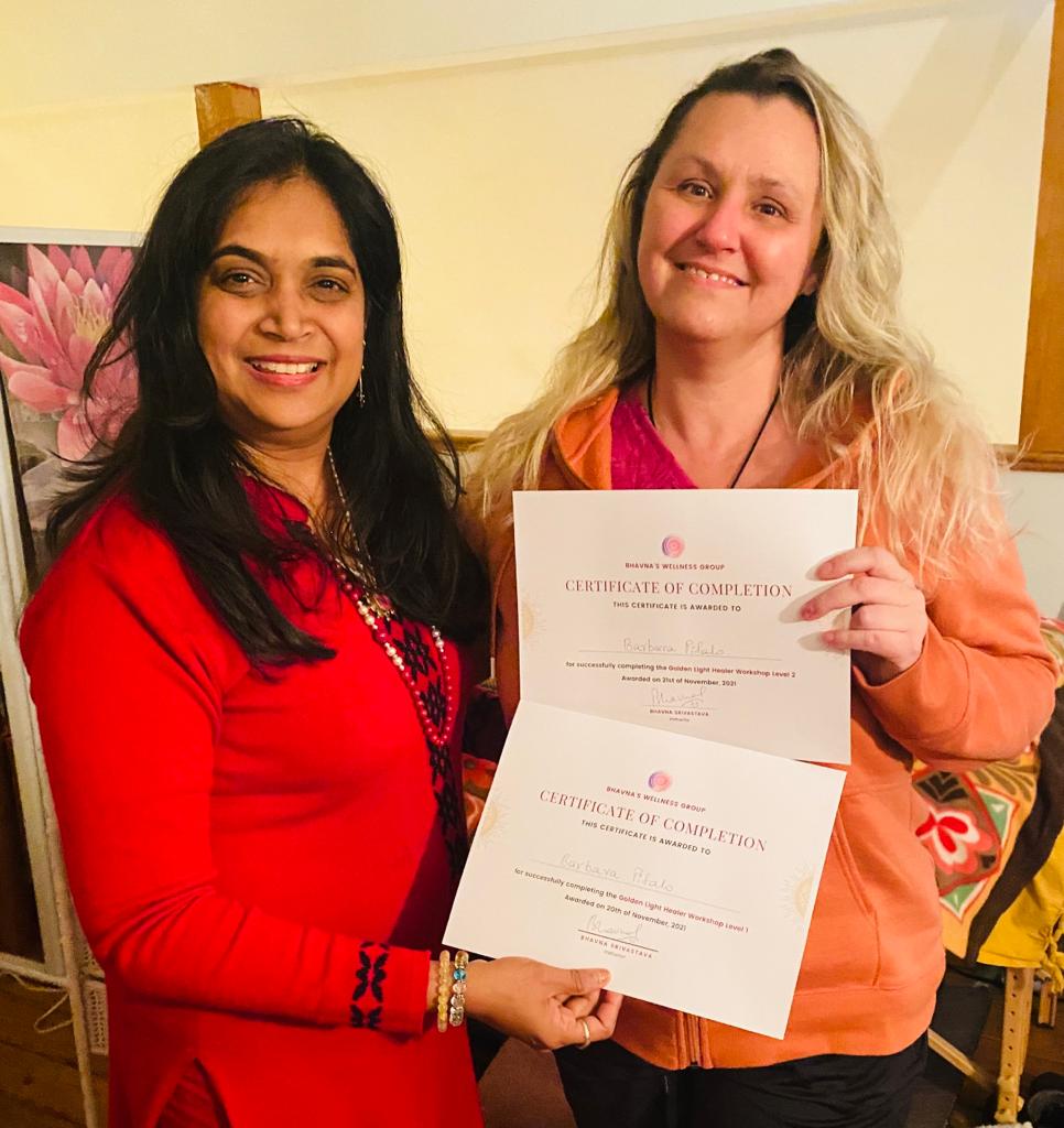 Bhavna Srivastava presenting a certificate of completion to a graduate in a peach cardigan