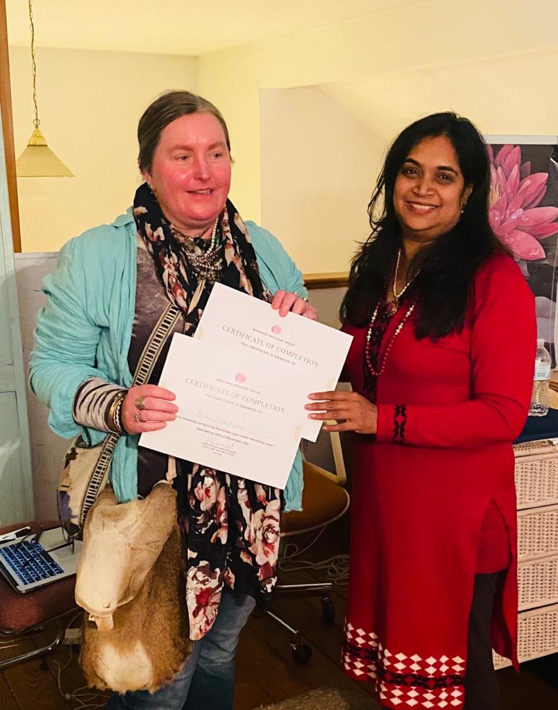Bhavna Srivastava presenting a certificate of completion to a graduate in a teal jacket