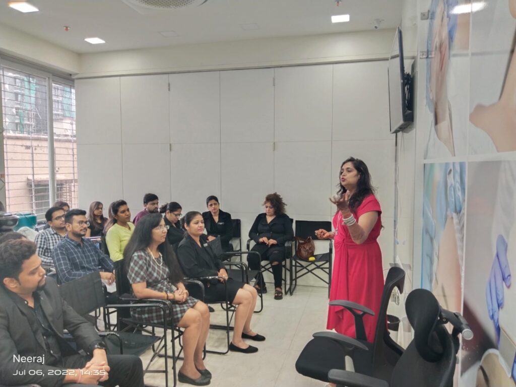 Bhavna Srivastava in a red kurta presenting to a small seated audience in a bright workshop room