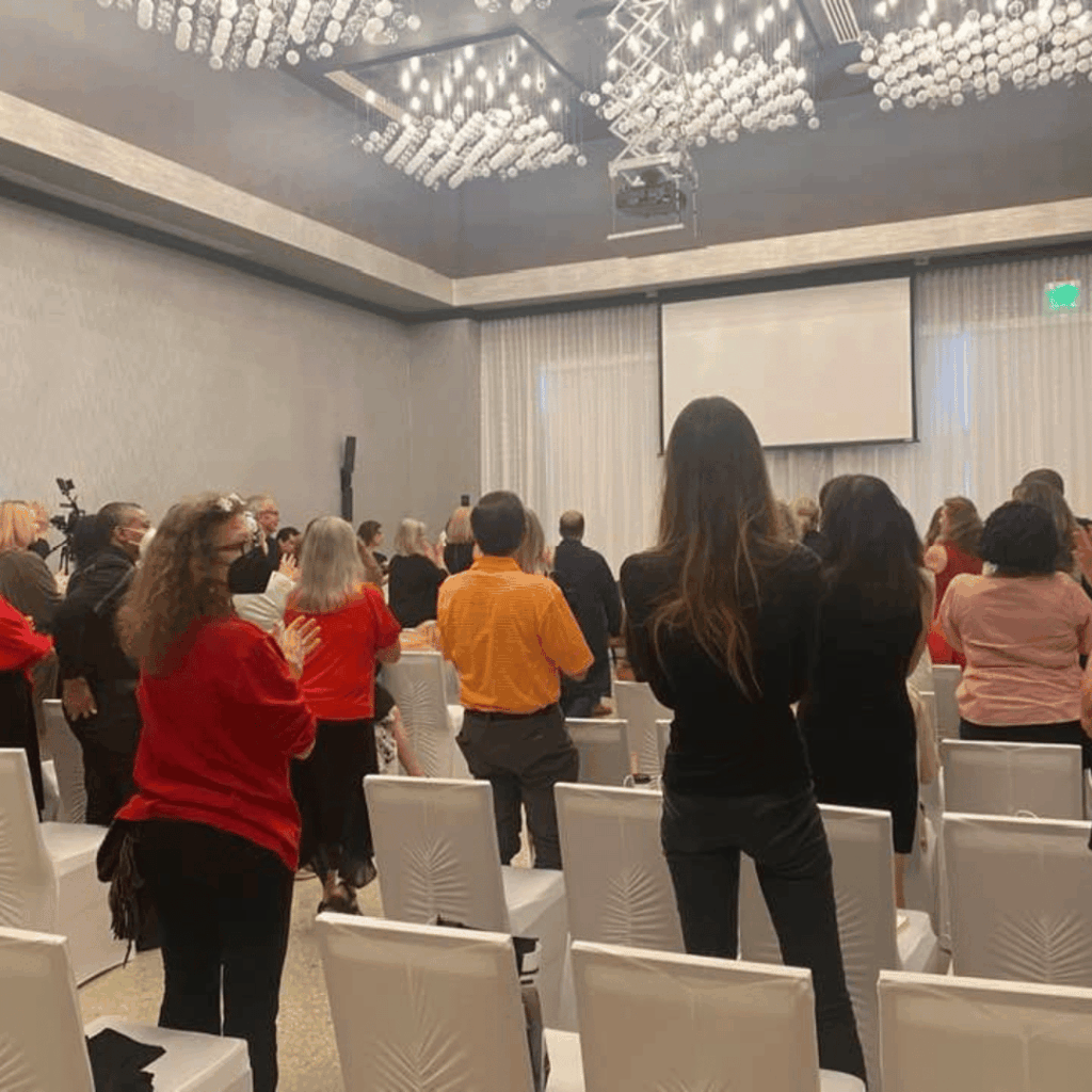 Attendees standing together at the front of a conference room