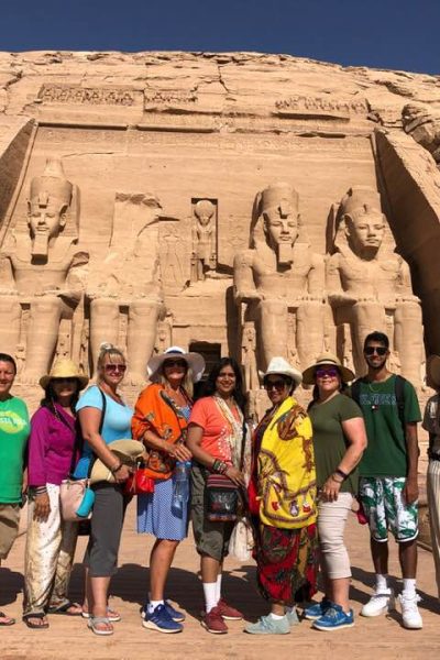 A tour group posed in front of the colossal statues at Abu Simbel, Egypt
